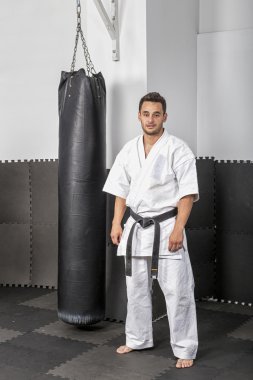 athletic black belt karate standing next a boxing ba clipart