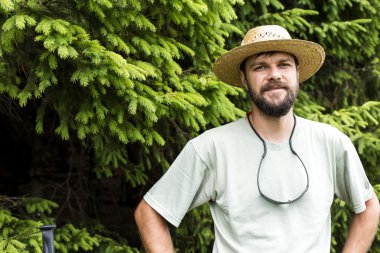 Sakal ve bir dağ çam ön plana şapka ile genç adam portresi