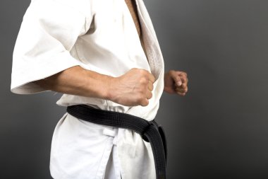 Genç adam beyaz kimono ve kara kuşak eğitimi savaş sanatı