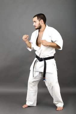 Beyaz kimono ve siyah kuşak genç adam tam uzunlukta portresi