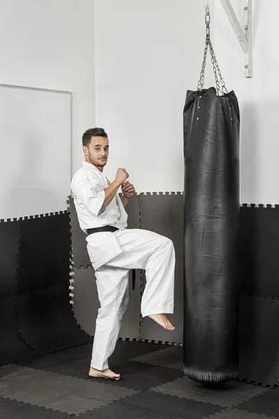 Atletismo cinturón negro karate dando una patada de rodilla contundente — Foto de Stock