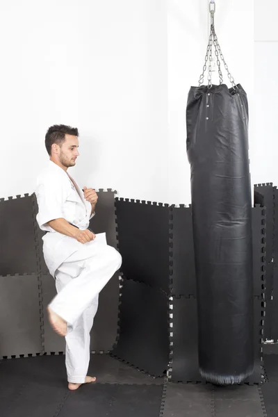 Luchador de karate atlético dando una patada fuerte en el pie a una pesada b — Foto de Stock