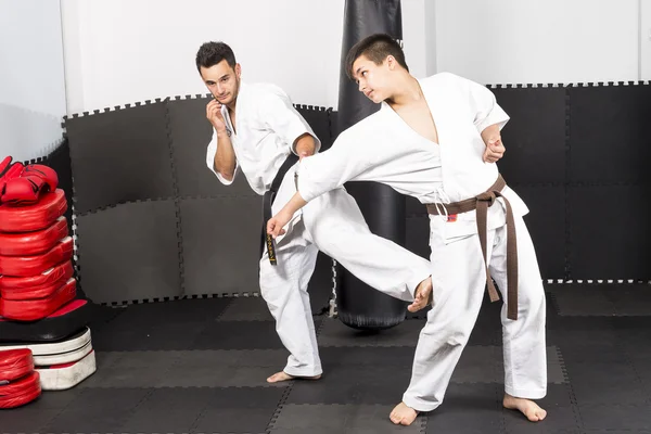 Dos jóvenes en kimono que luchan ashihara karate-durante su t — Foto de Stock