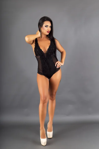 Sensual mujer morena posando en lencería negra sexy y alta que — Foto de Stock