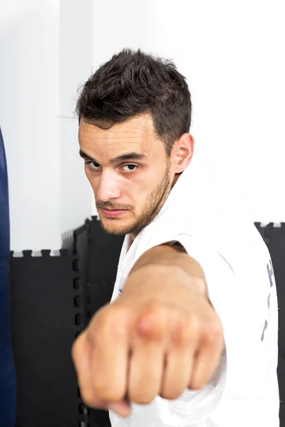 Jonge man een punch gooien tijdens zijn training op de sportschool — Stockfoto