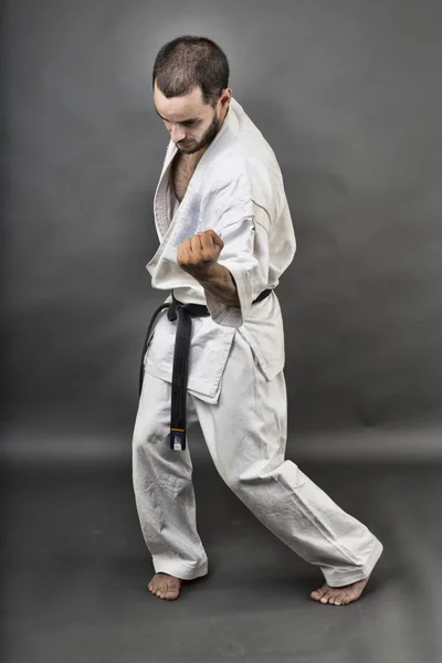 Volledige lengte portret van jonge man in de witte kimono en zwarte gordel — Stockfoto