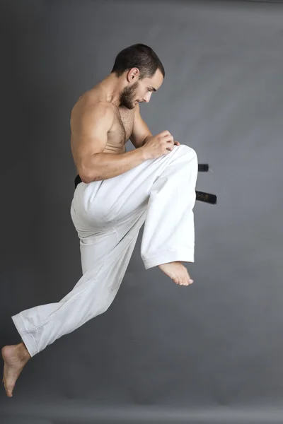Joven en kimono blanco y cinturón negro de entrenamiento de arte marcial — Foto de Stock