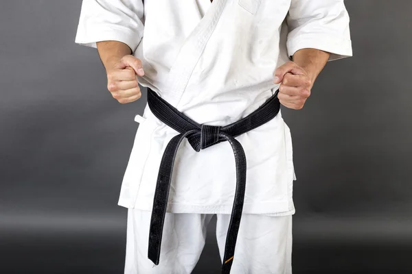Joven en kimono blanco y cinturón negro de entrenamiento de arte marcial — Foto de Stock