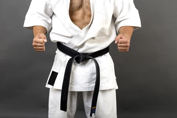 Joven en kimono blanco y cinturón negro de entrenamiento de arte marcial — Foto de Stock