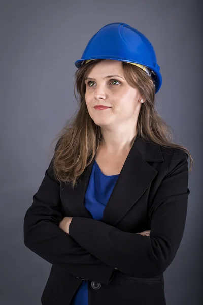 Happy young engineer woman with hardhat and arms folded — Stock Photo, Image