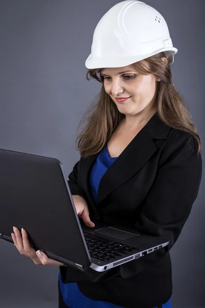 Ingeniera femenina de pie y usando su portátil —  Fotos de Stock