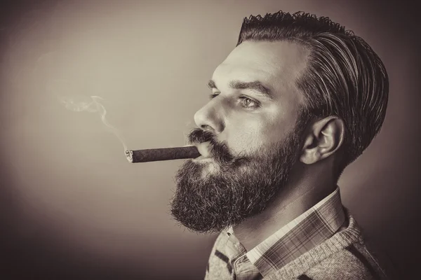 Handsome young man with retro look smoking a cigar — Stock Photo, Image