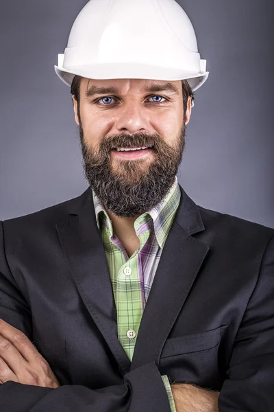 Primer plano del joven ingeniero con los brazos cruzados de la celebración del hardhat — Foto de Stock