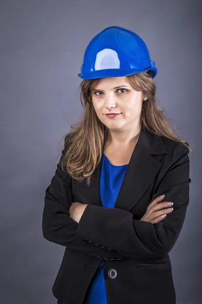 Joyeux jeune ingénieur femme avec casque et bras pliés — Photo