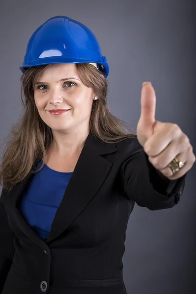 Glad ung kvinna med hardhat visar ok tecken — Stockfoto