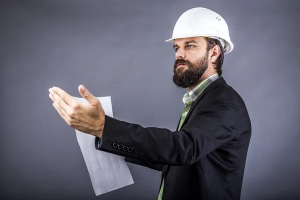 Retrato de un joven ingeniero sosteniendo planos y explicando — Foto de Stock