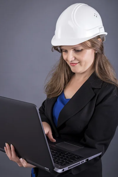 Kvinnliga ingenjör ständiga och använder sin laptop — Stockfoto