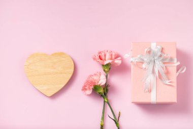 Hediye kutusu, karanfil çiçekleri, Anneler Günü ve Sevgililer Günü mesajı için içi boş bir kalp.