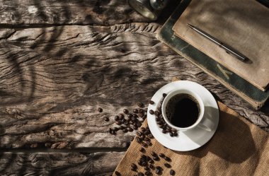 Hurma yaprağının gölgesinde kahve fincanı, güneş ışığında kahve.