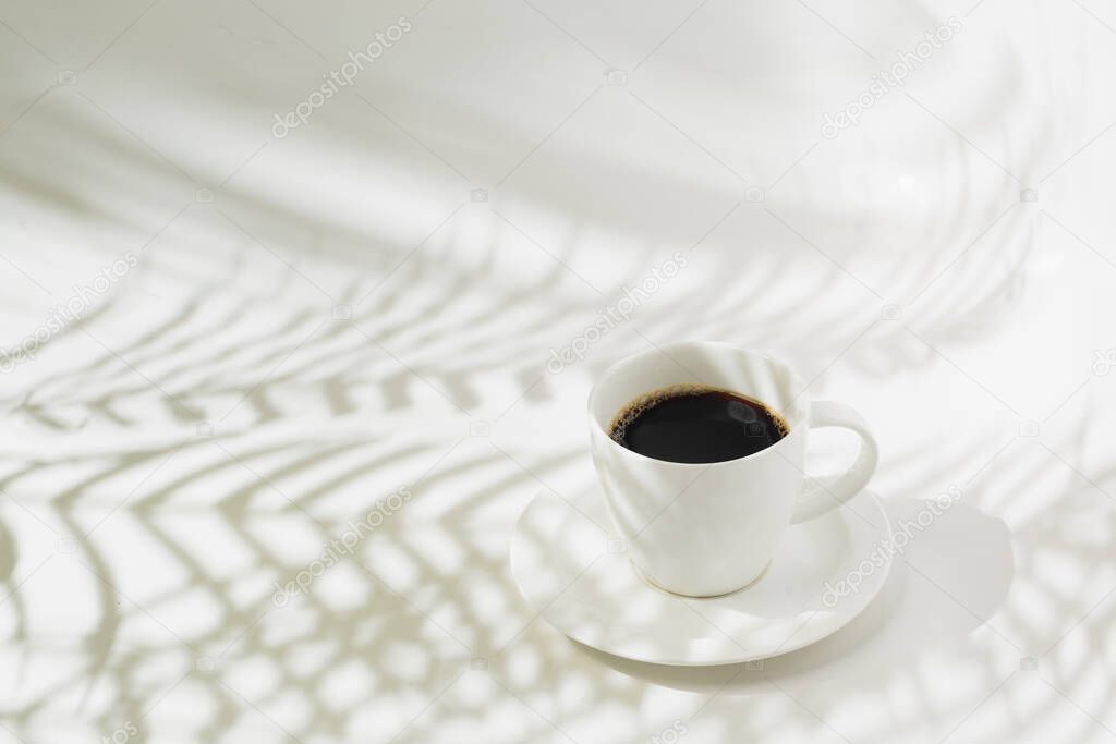 Hot black coffee and palm leaf silhouette
