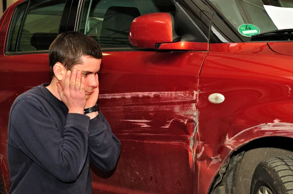 Hasarlı arabası ile araç sürücüsü.