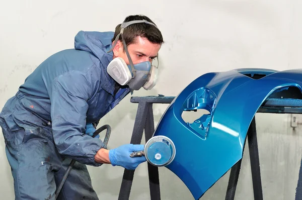Worker painting blue bumper. — Stock Photo, Image