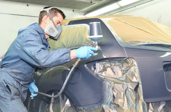 Arbeiter beim Bemalen eines grauen Autos in einer Lackkammer. — Stockfoto