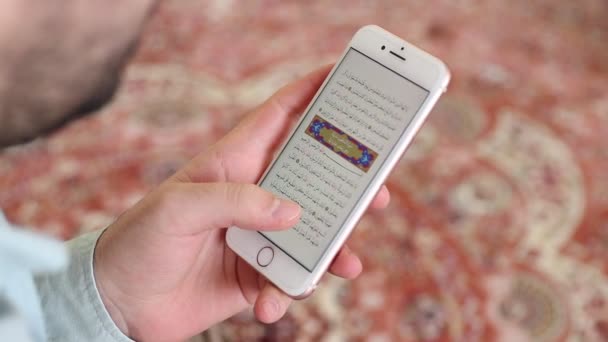 Jonge moslim die koran leest in moskee met mobiele telefoon — Stockvideo