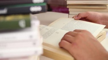 Kitap yığınları arasında oturup kitap okumak