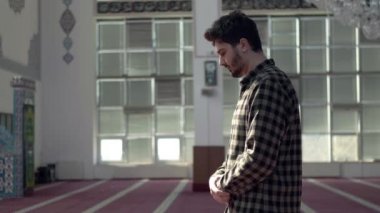 Camide namaz kılan bir genç adam.