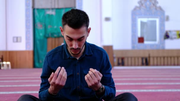 Ο άνθρωπος σηκώνει τα χέρια του και προσεύχεται από το τζαμί. — Αρχείο Βίντεο