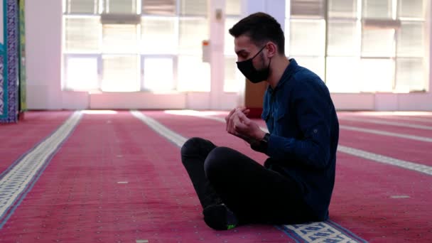 Man maskerade upp sina händer och åberopa från moskén — Stockvideo