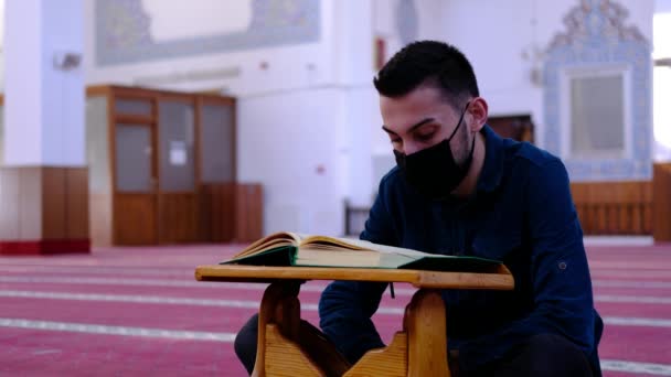 Laki-laki bertopeng yang membaca Al Qur 'an masjid — Stok Video