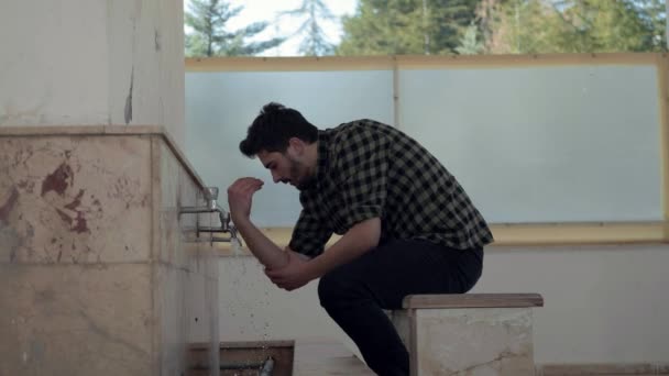 Young Muslim man taking ablution for prayer the mosque — Stock Video