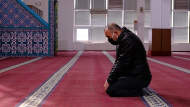Старик в маске поворачивает голову мечеть — стоковое видео