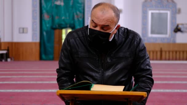 Oude gemaskerde man leest koran ramadan maan — Stockvideo