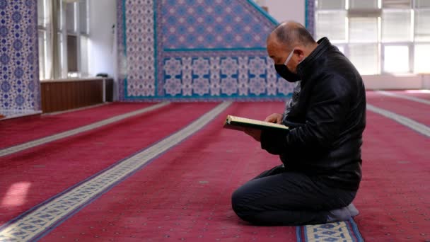 Hombre enmascarado leer la mezquita del Corán — Vídeo de stock