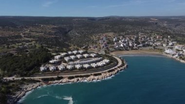 Deniz ve dağ manzaralı beyaz tatil evlerinin havadan görünüşü