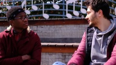 Siyah ve beyaz genç adam konuşuyor.