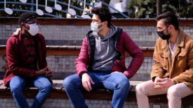 Siyah ve beyaz maskeli adam konuşuyor.