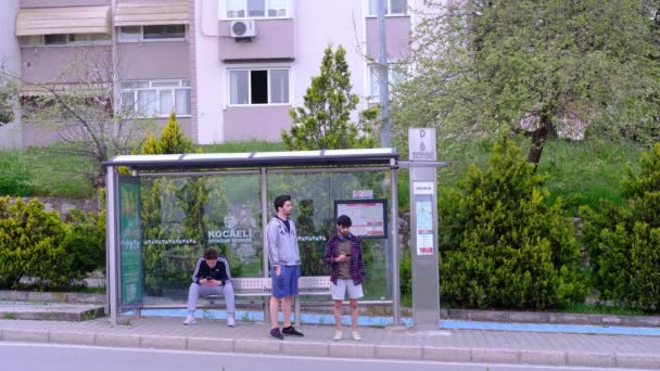 Молодой человек автобусная остановка — стоковое видео