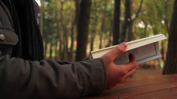 Fechar vista homem leitura livro no outono parque — Vídeo de Stock