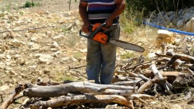 Elektrikli testereyle odun kesen adam.