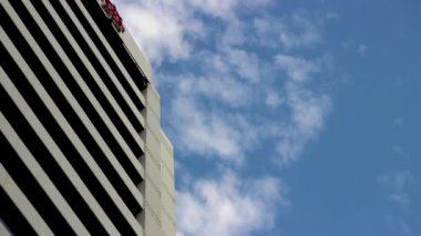 Şehir, cam binalar, bina ve güneşli gökyüzü arasında bağımsız olarak gidip geliyor.