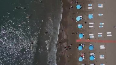 Kumsaldaki insanlar güneşleniyor.