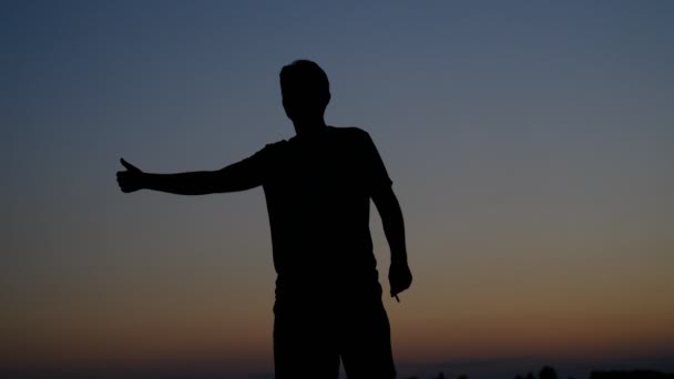 Young man hitchhiker silhouette — Stock Video