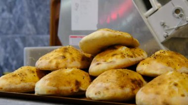 Taze pişmiş ekmekler üst üste dizilmiş.