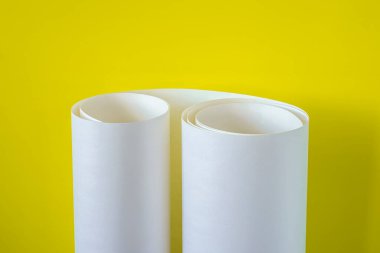 Sarı zemin üzerinde beyaz kağıt rulo.