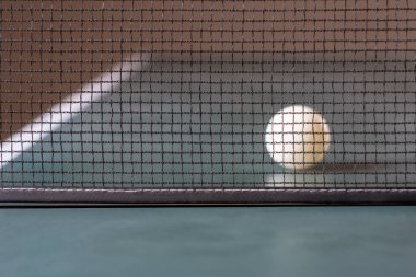 Bulanık arkaplanda masa tenisi ve top.