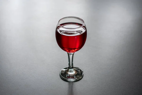 Glass of red wine on a dark background.